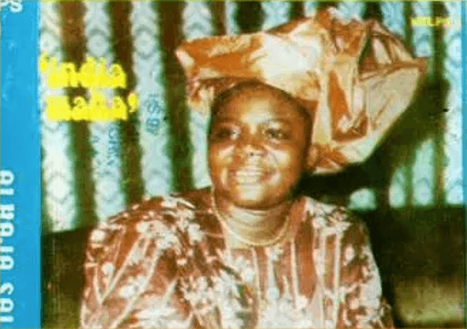 Queen Salawa Abeni cheek to cheek with a fellow performer singing into a microphone, from a record sleeve marked KRLPS 14
